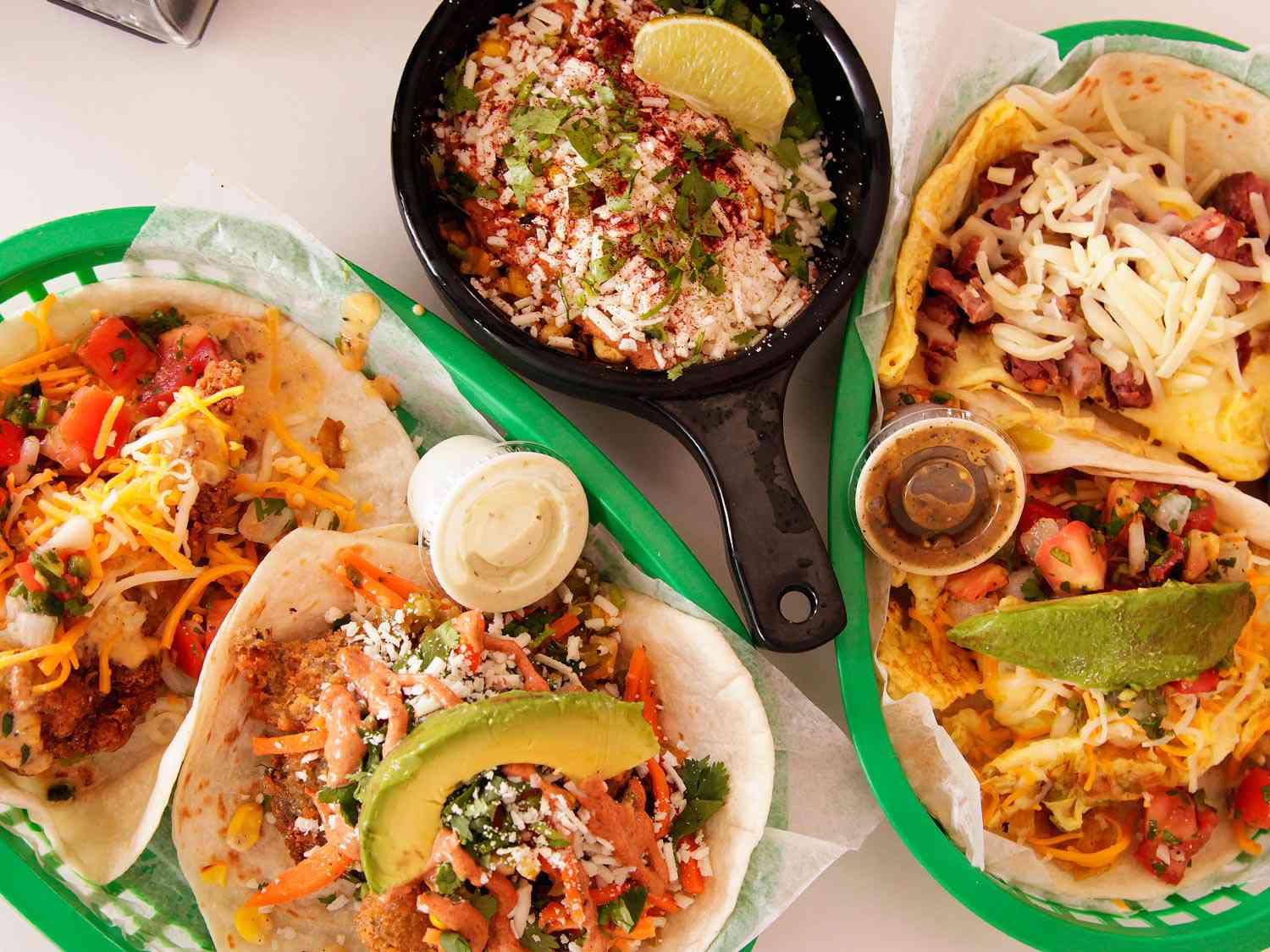 Trays of tacos and a small pan of esquites from Torchy's Tacos 