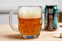 A dimpled pint glass filled with beer.