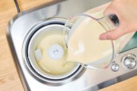 A hand pouring liquid into the Breville Smart Scoop Ice Cream Compressor