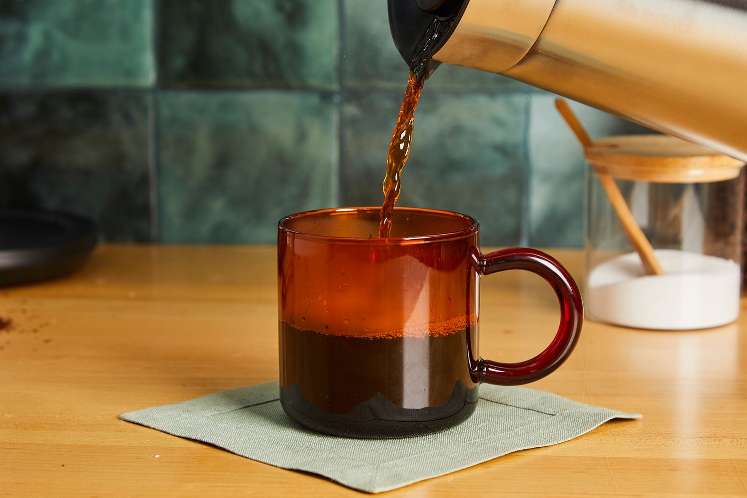 Coffee being poured into an amber glass coffee mug.