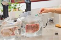 Meat sealed in the Anova Precision Vacuum Sealer Pro is submerged in water