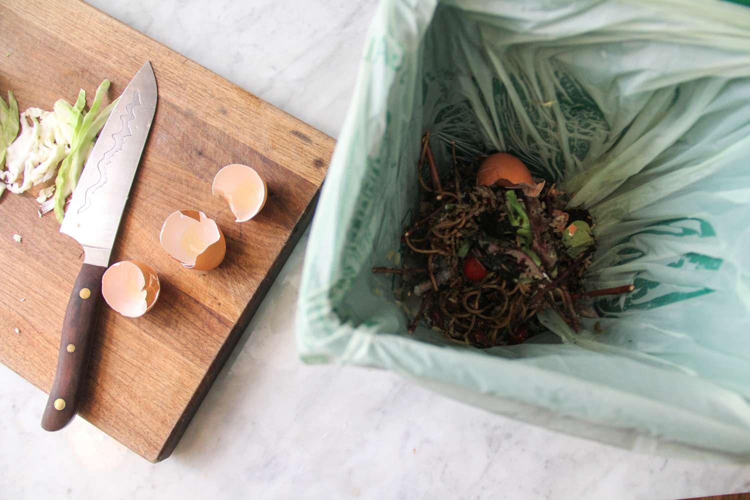 Exaco Eco 2000 kitchen compost pail open next to a cutting board