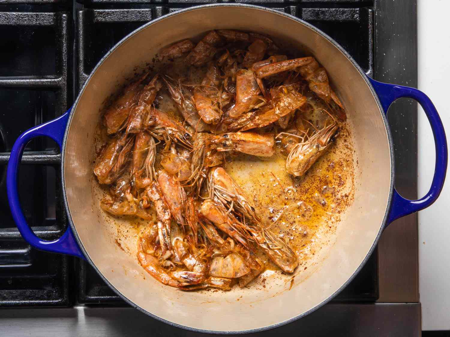 Shrimp shells and heads browning in a Dutch oven.
