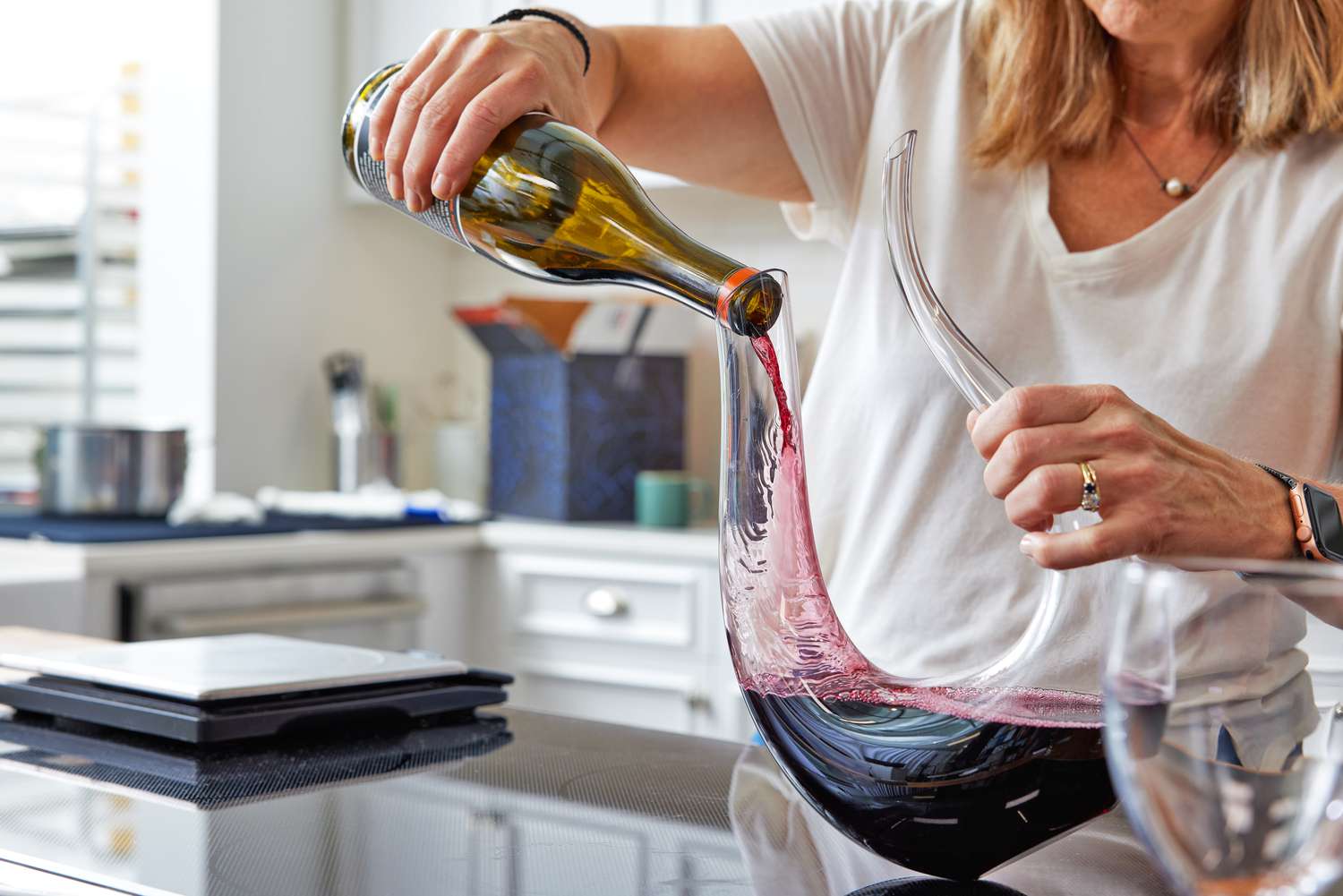 Pouring red wine into a swan wine carafe