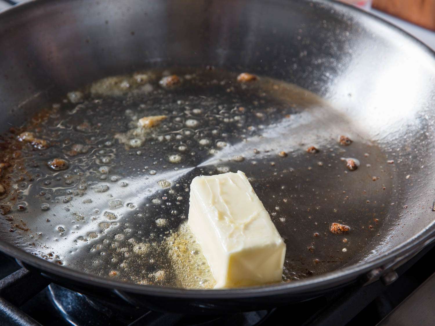 A stick of butter being melting in a pan.