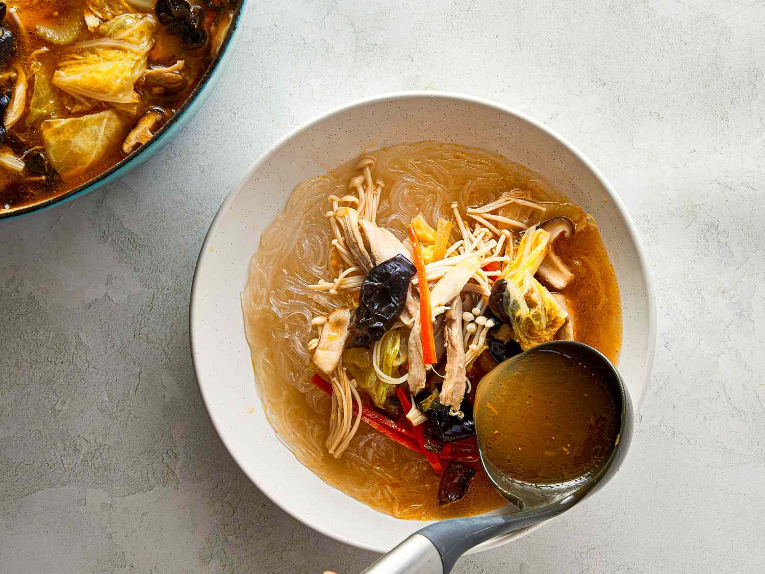 Bowl of chicken sotanghon soup with noodles and vegetables