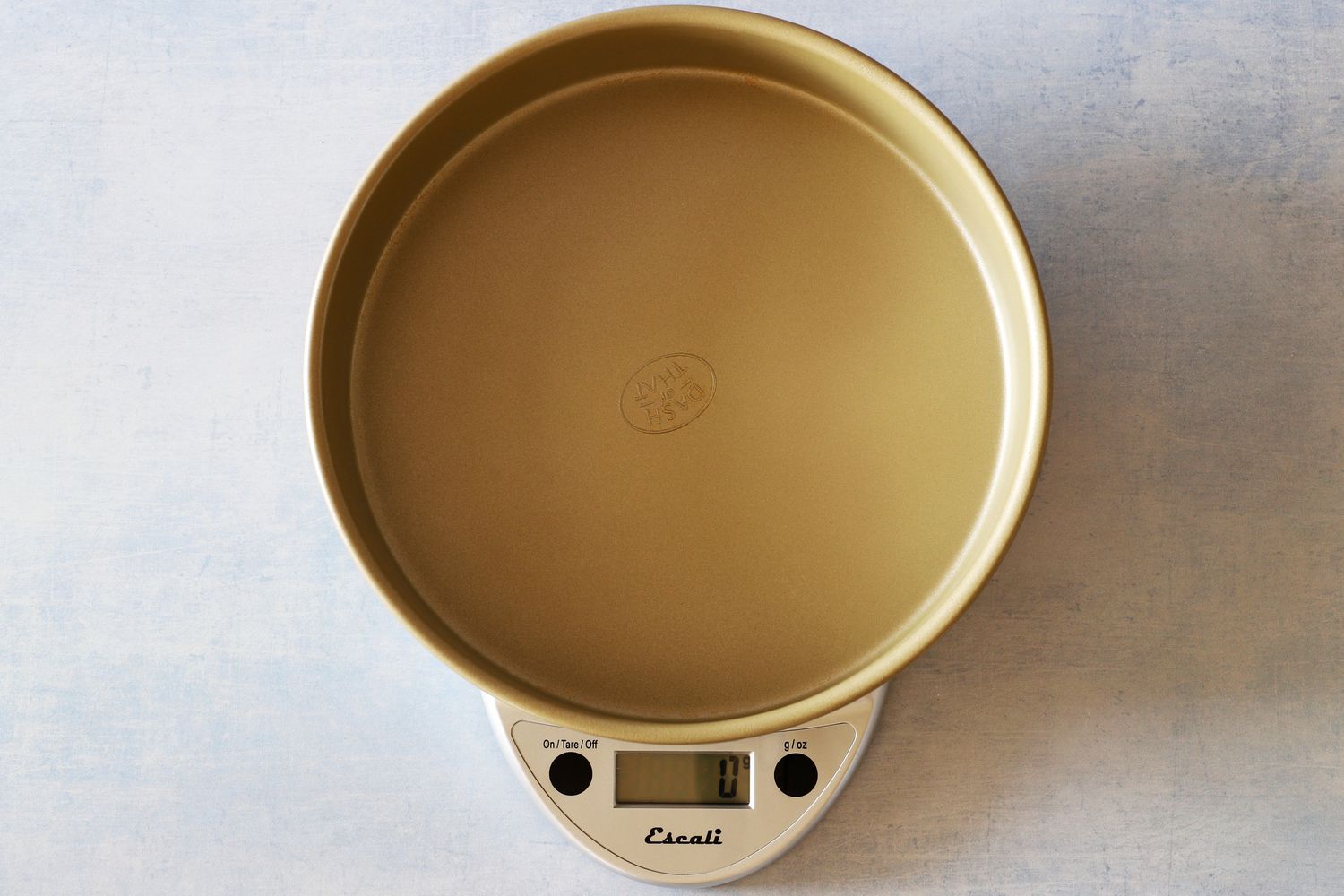 The Escali kitchen scale with an empty cake pan on it.