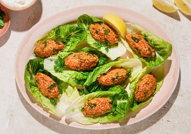 Turkish lentil koftes served on lettuce leaves with lemon wedges