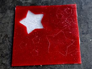 A square of homemade strawberry fruit roll-up with star cut-out.