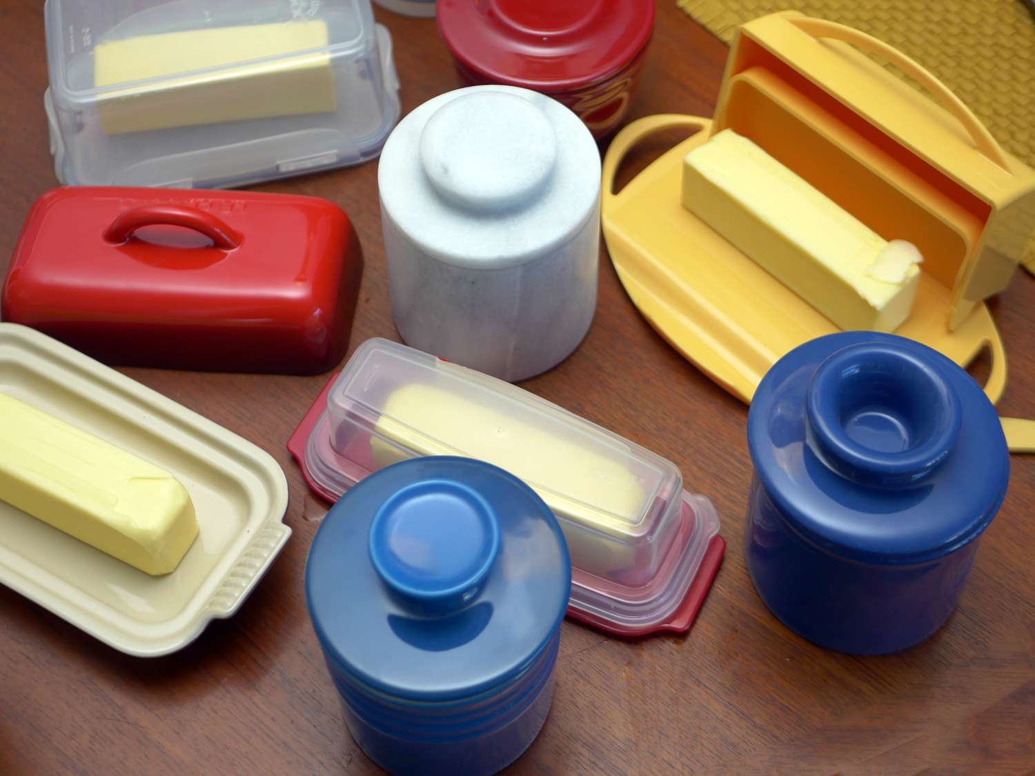 a variety of butter containers on a wooden surface