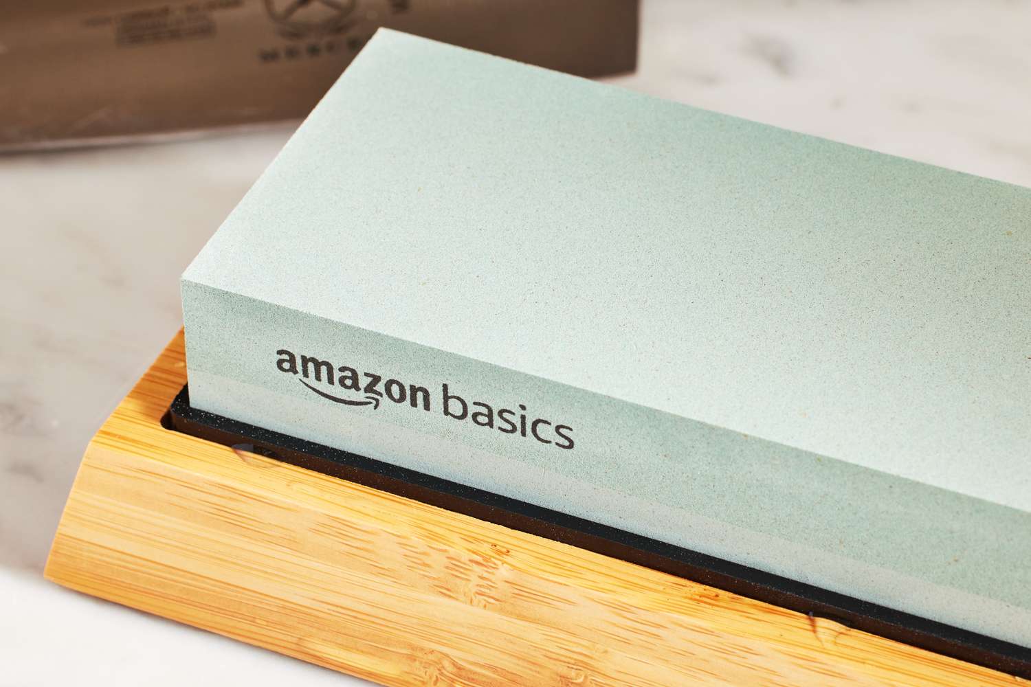 Amazon Basics knife sharpening whetstone on a wooden base