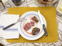 williams sonoma steak knife resting on a plate with sliced steak