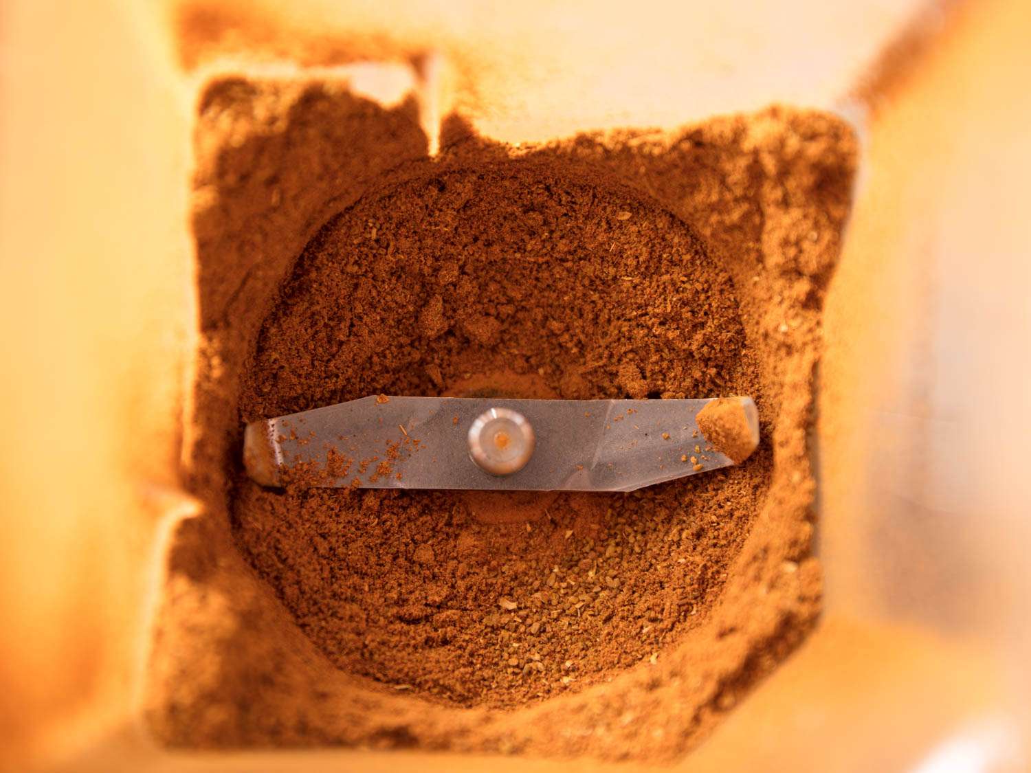 The toasted and ground chaat masala spices inside of the bowl of a high speed blender.