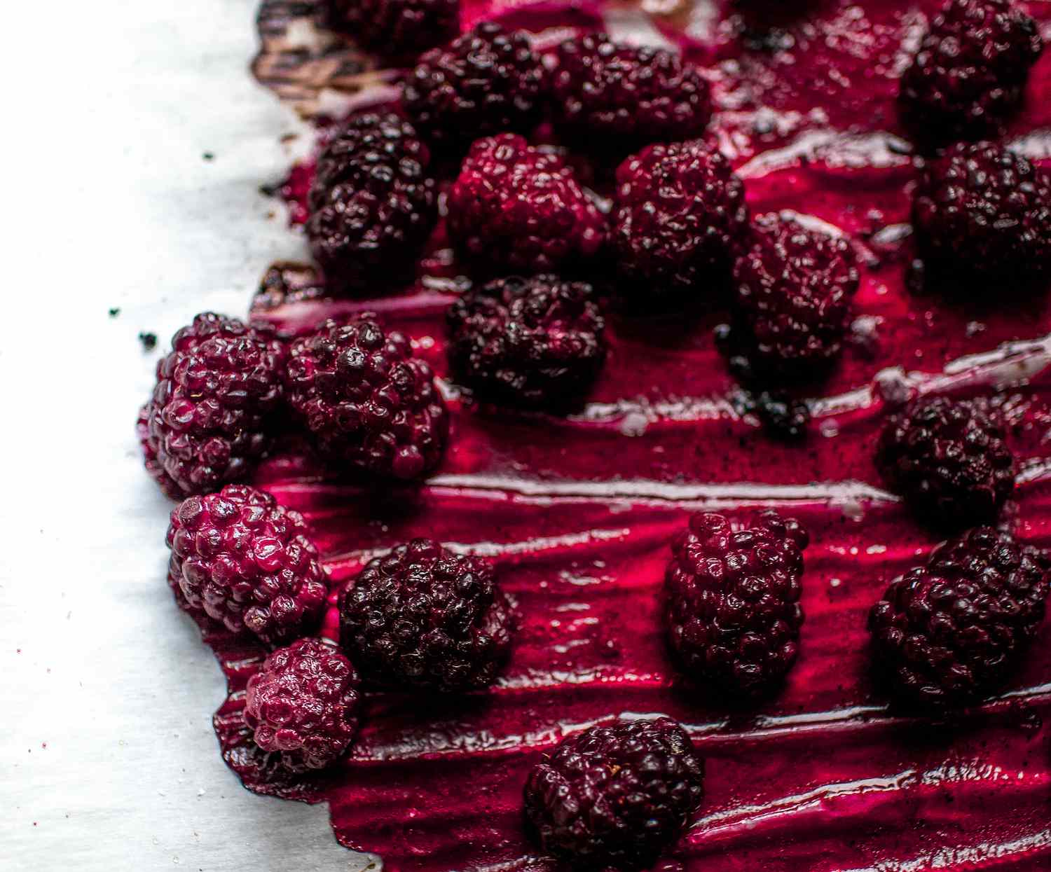 Cooked marionberries on a piece of parchment paper.