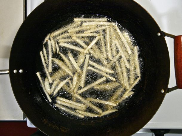 Deep-frying french fries in a wok.