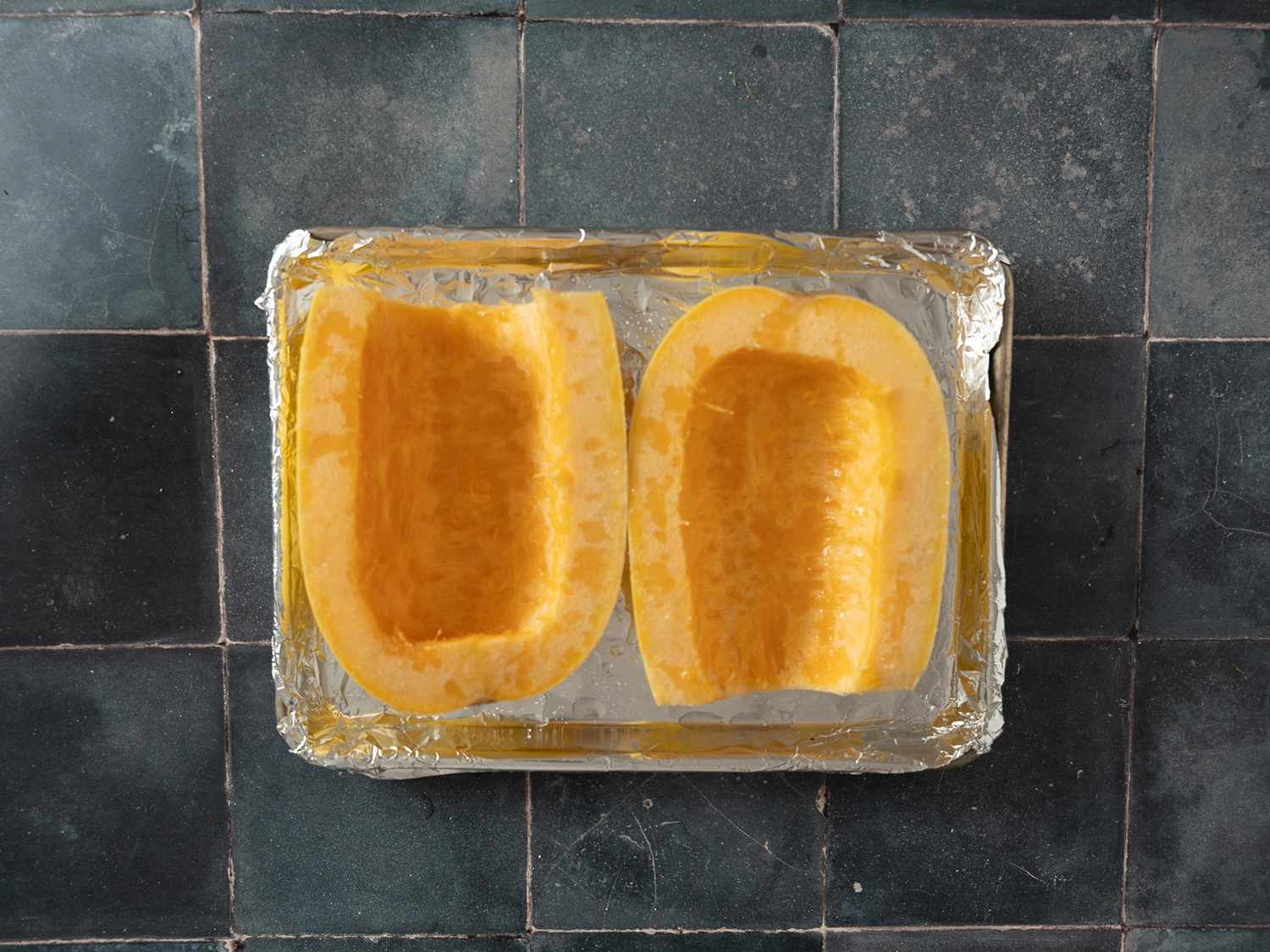 Spaghetti squash, halved with seeds removed, placed cut-side up on a roasting pan lined with foil