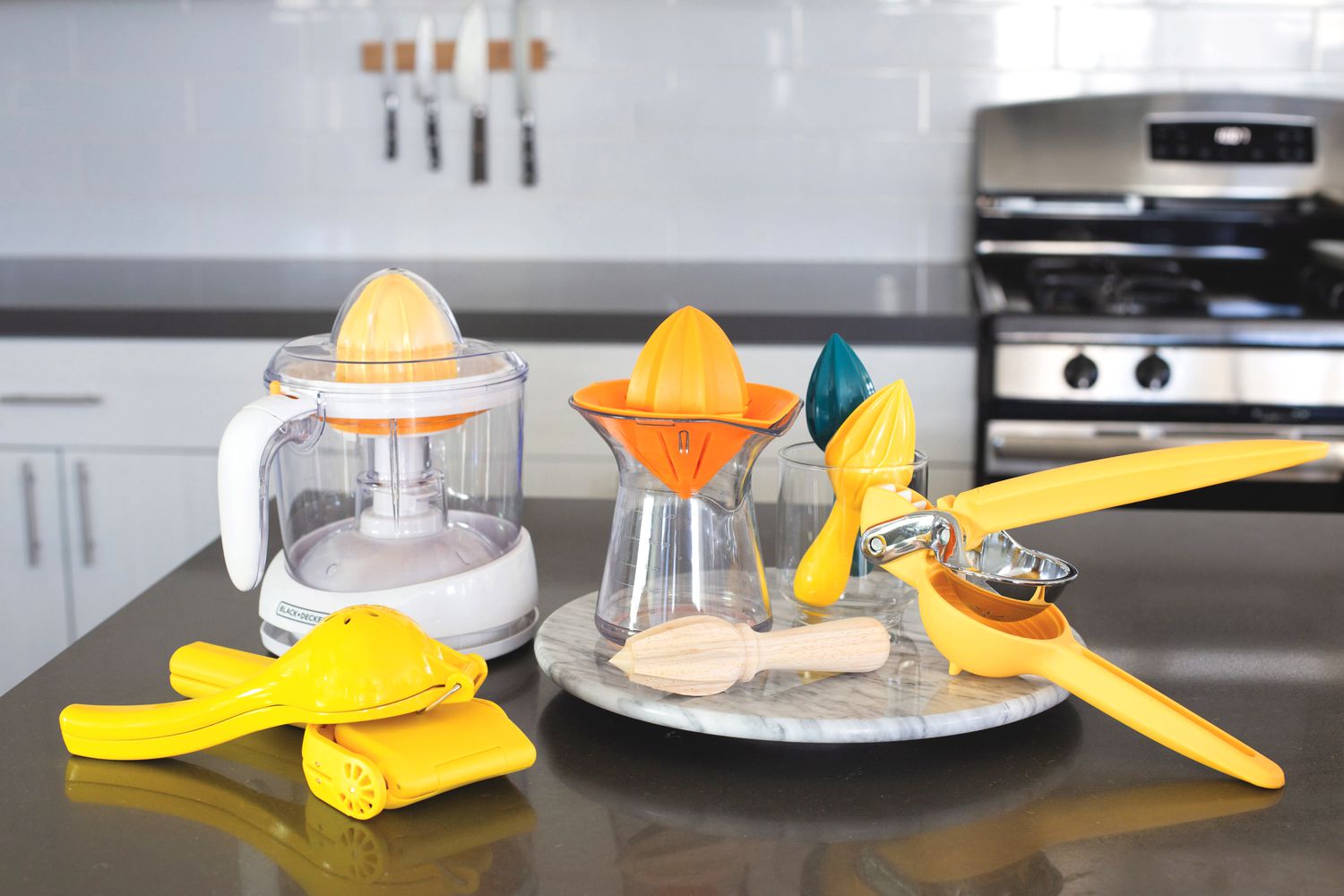 Various types of citrus juicers on a kitchen countertop.
