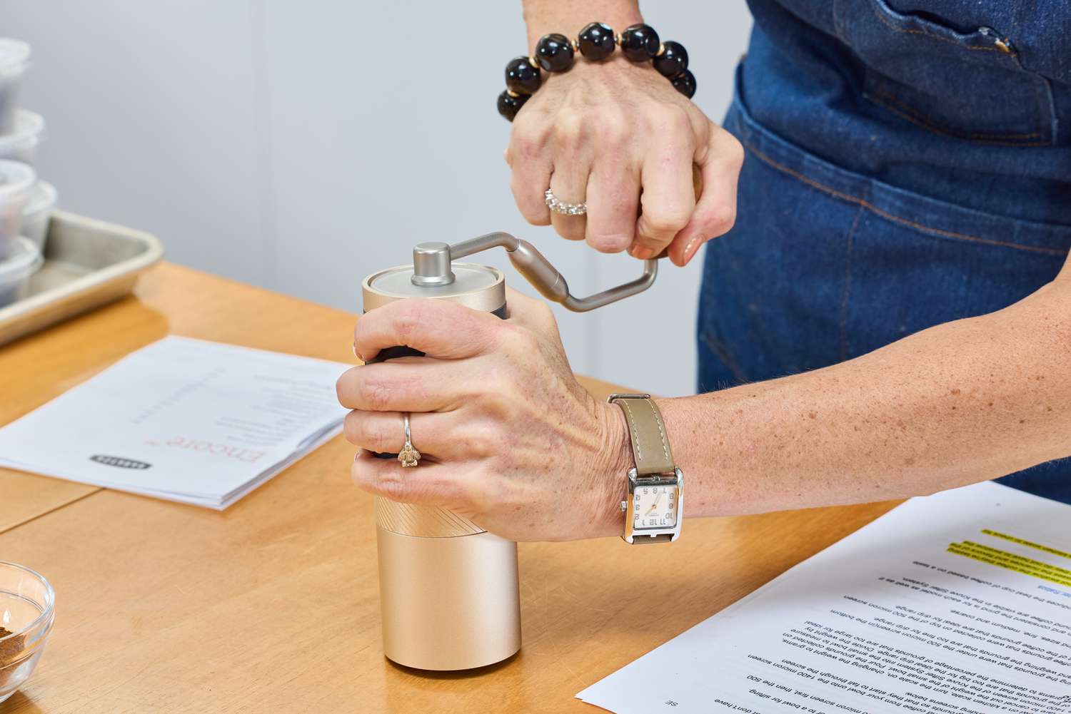 A person turns the crank on the top of the 1Zpresso J Manual Coffee Grinder