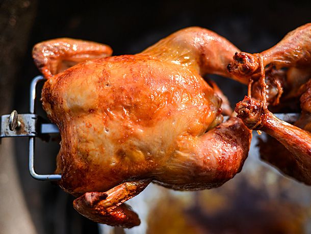 Closeup of rotisserie chicken on the spit prepared according to the modified recipe. It looks golden brown. 