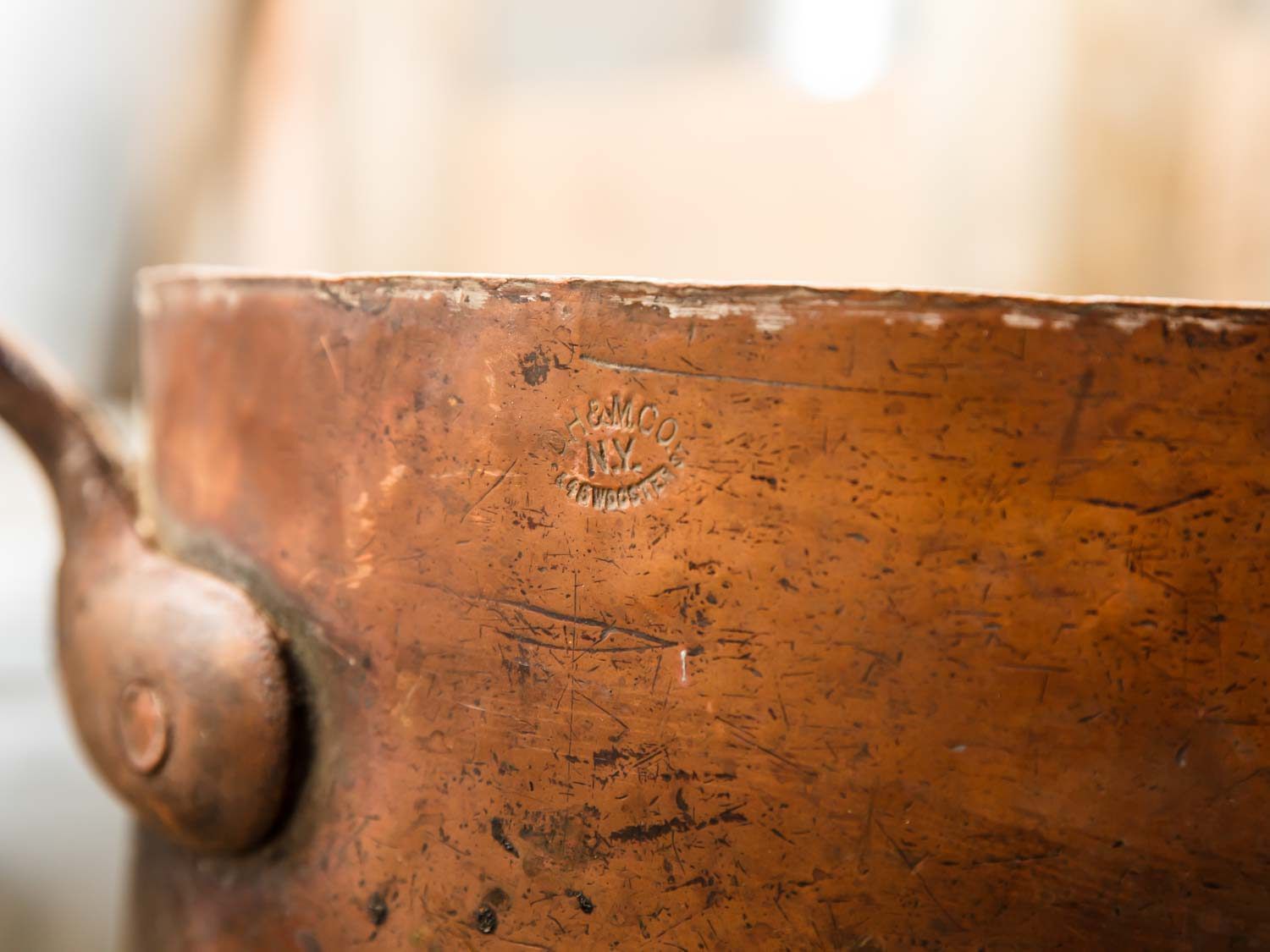A close-up of the company stamp on a piece of vintage copper cookware