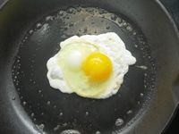 A fried egg in a cast iron skillet