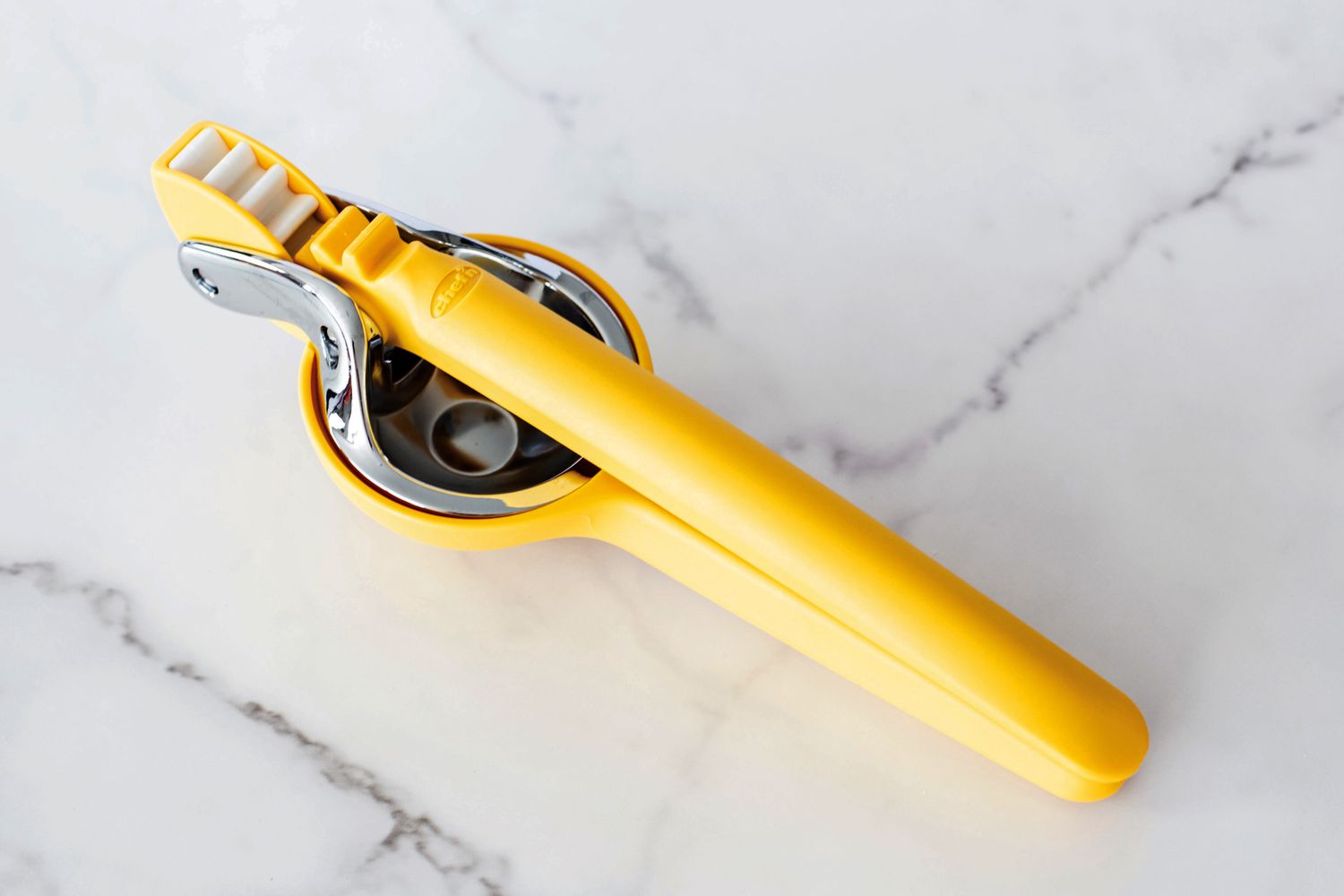 The Chef'n citrus juicer on a marble countertop.