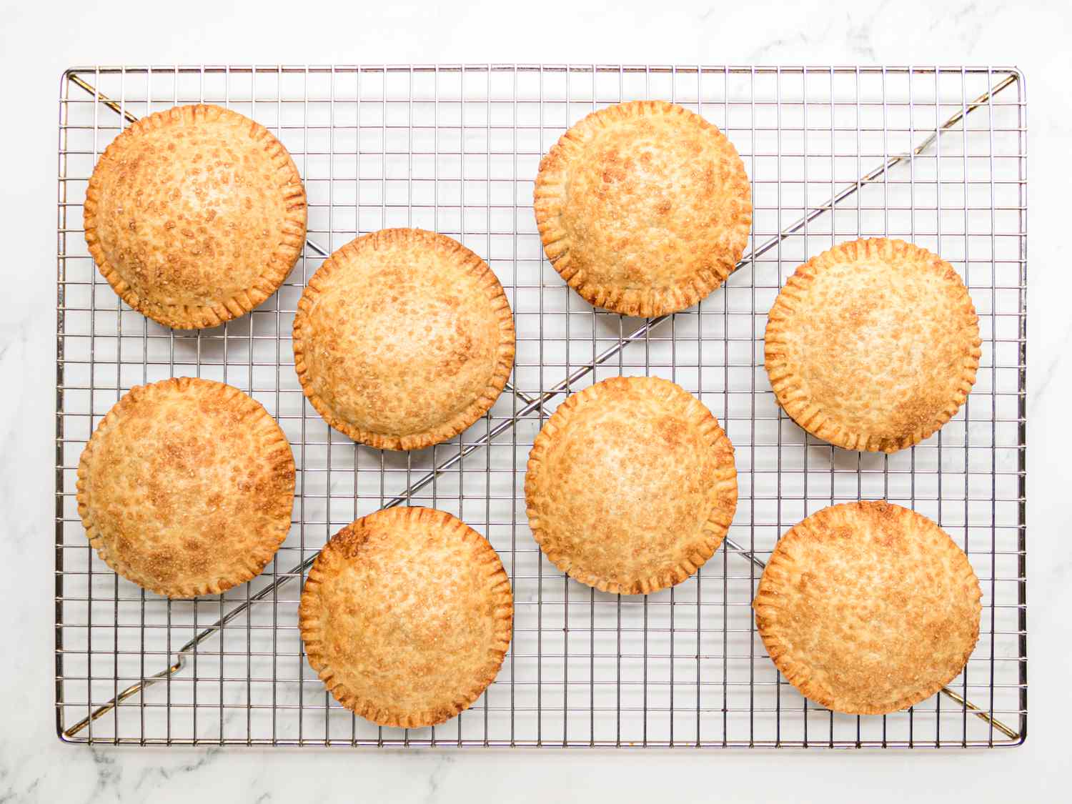 Baked handpies, golden brown and cooling on a wire rack 