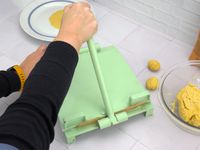 a person pressing tortillas