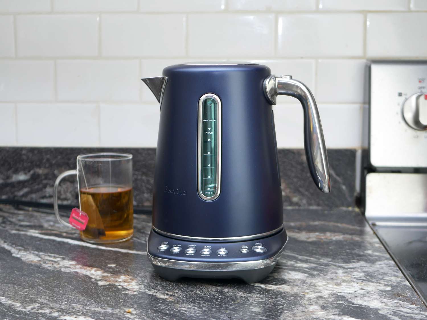 breville variable electric kettle on countertop with cup of tea behind it