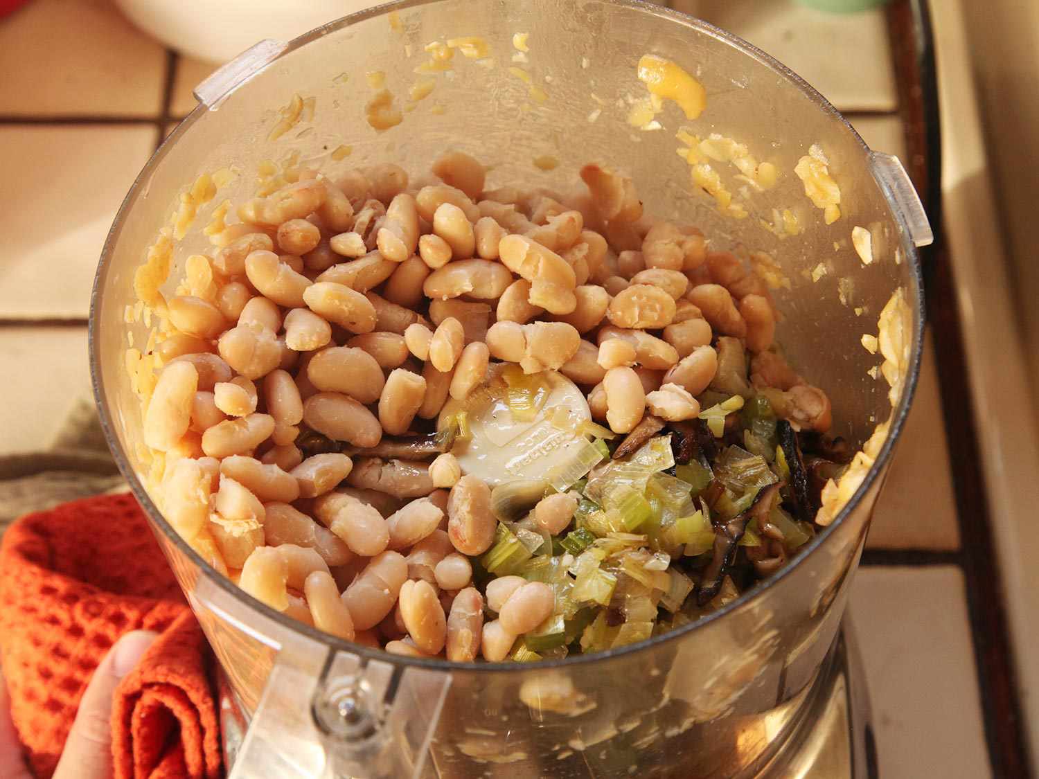 Cannellini beans and shiitake mixture in bowl of food processor.