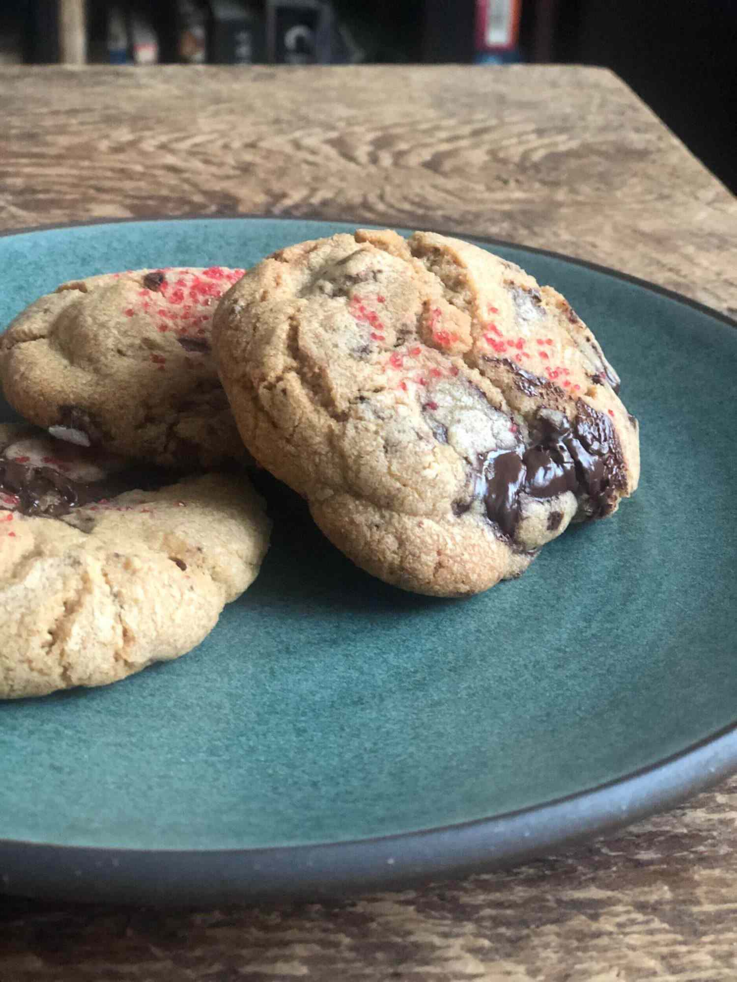 three chocolate cookies arranged on a green plate