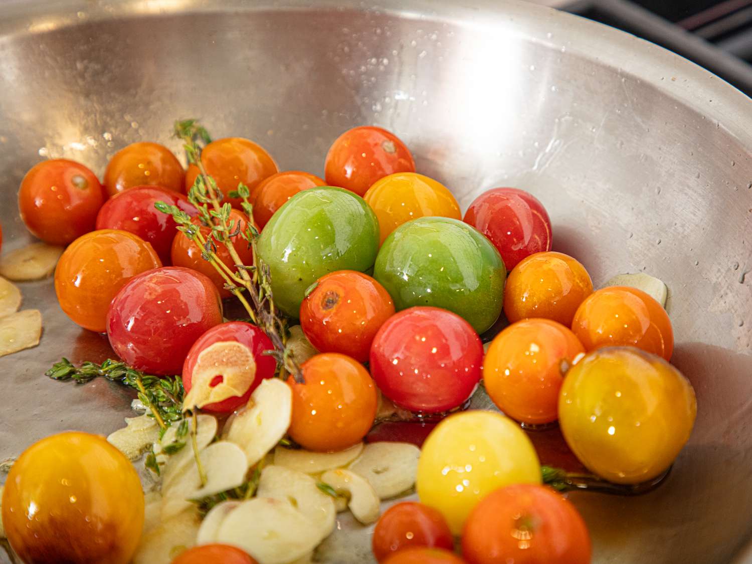 Cherry tomatoes with garlic and thyme in a metal skillet