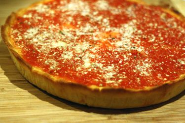 Frozen deep dish pizza on a cutting board