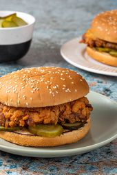 Two fried chicken sandwiches on ceramic plates.