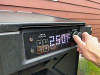 A person adjusts the temperature on the Traeger Woodridge grill