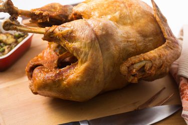 A deep fried turkey on a cutting board.