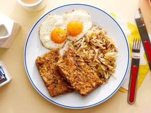 Overhead view of scrapple on a plate with eggs and hashbrowns