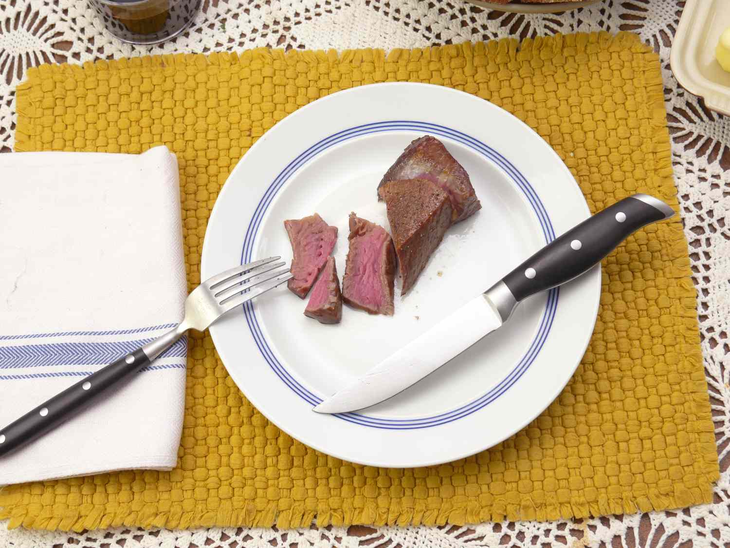 the quince steak knife resting on a plate with slices of steak