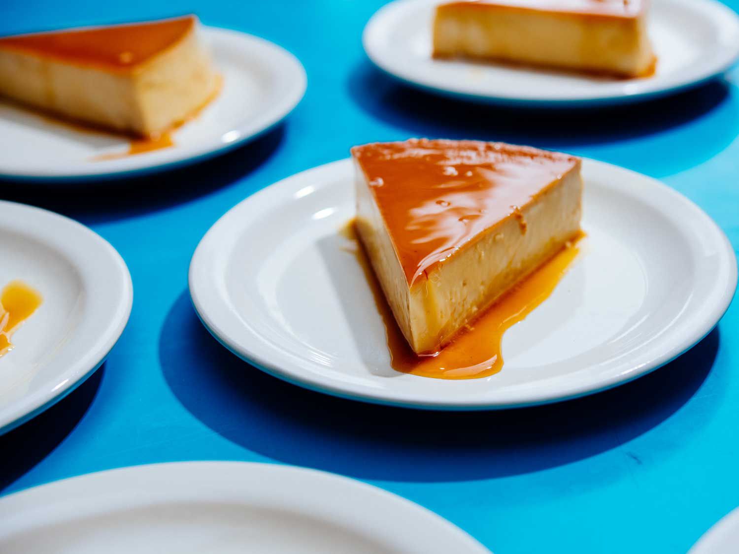 Several plates of sauce-covered flan at Cane & Table