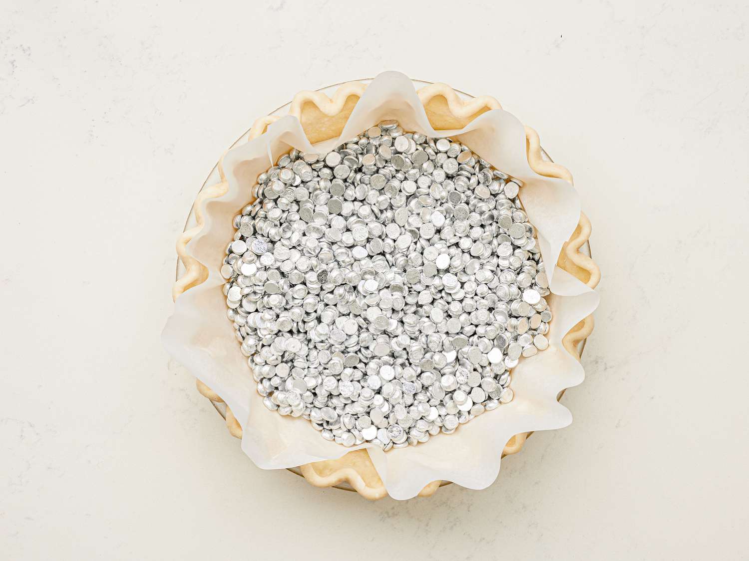 Overhead view of pie shell filled with pie weights.