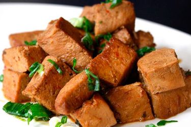 A plate of frozen tofu braised in soy sauce. 