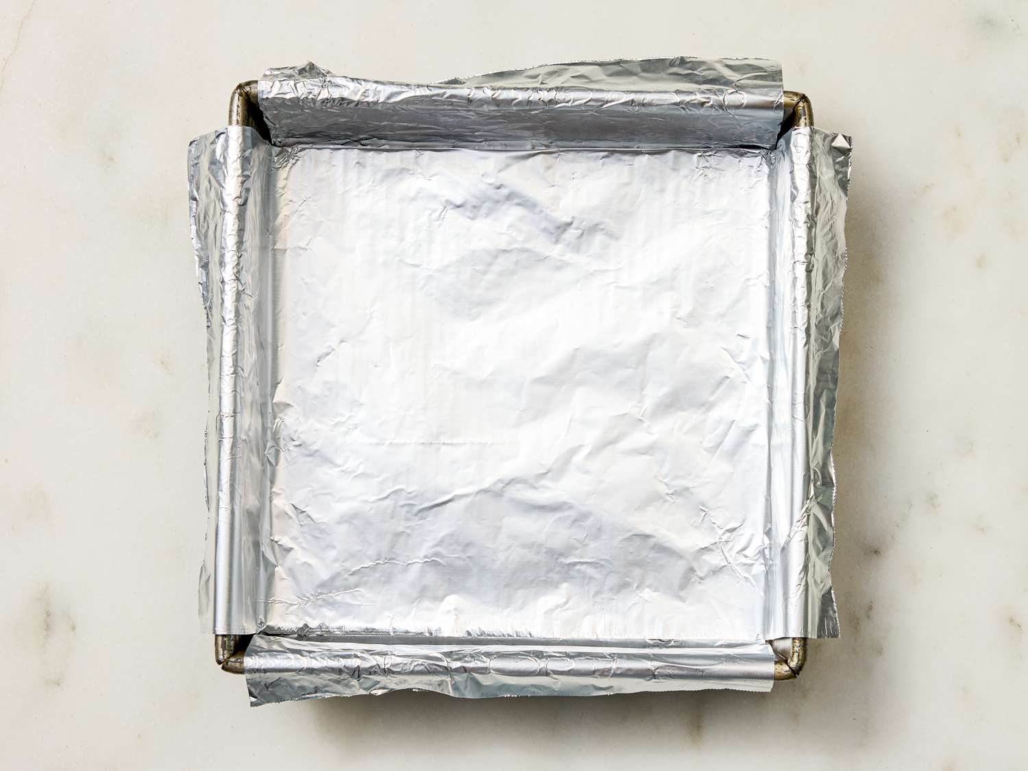 Foillined square baking pan placed on a flat surface
