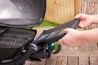 Hand unfolding the side tray on the Weber Q 1200 grill
