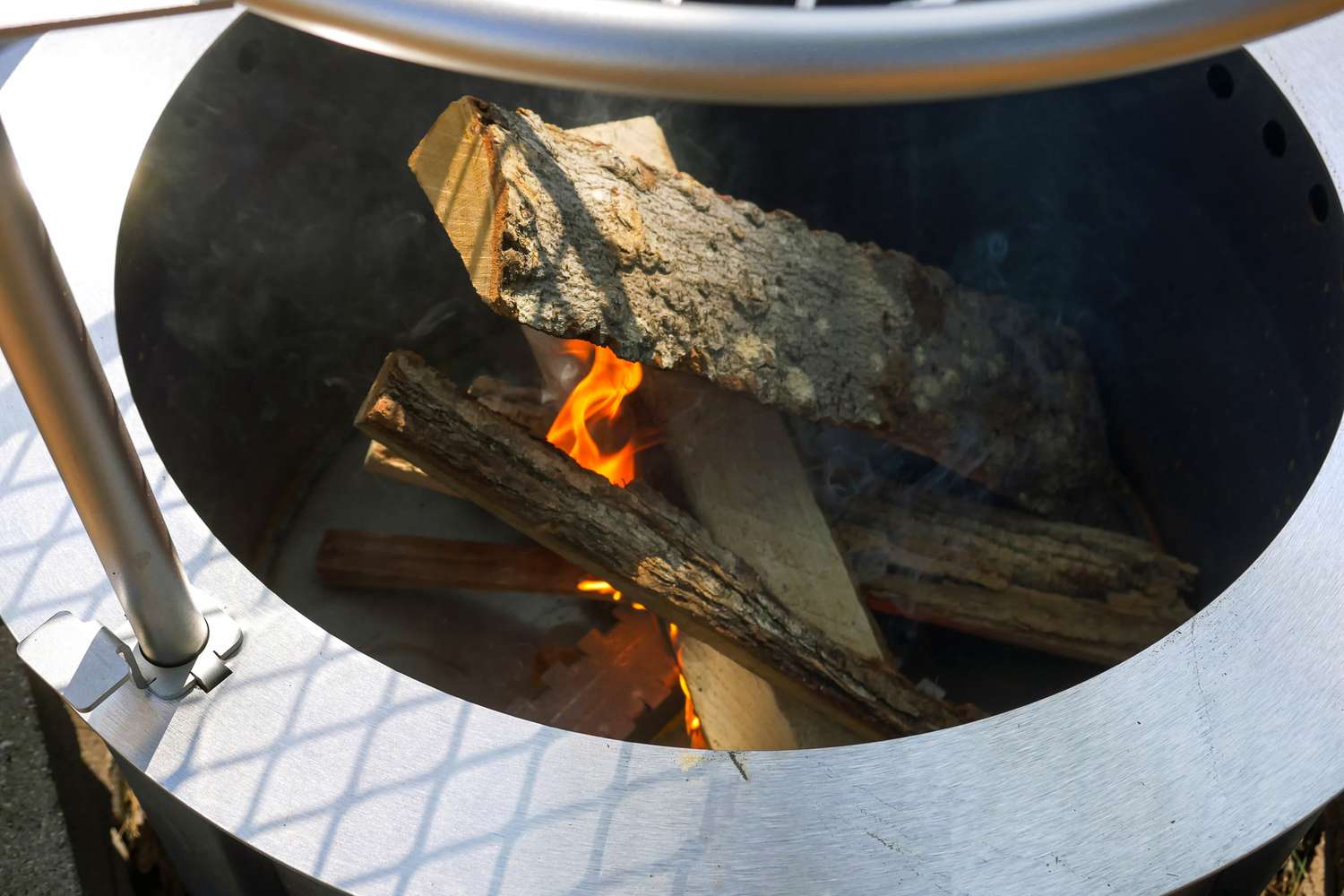 A close-up view of a fire pit with burning wood logs inside
