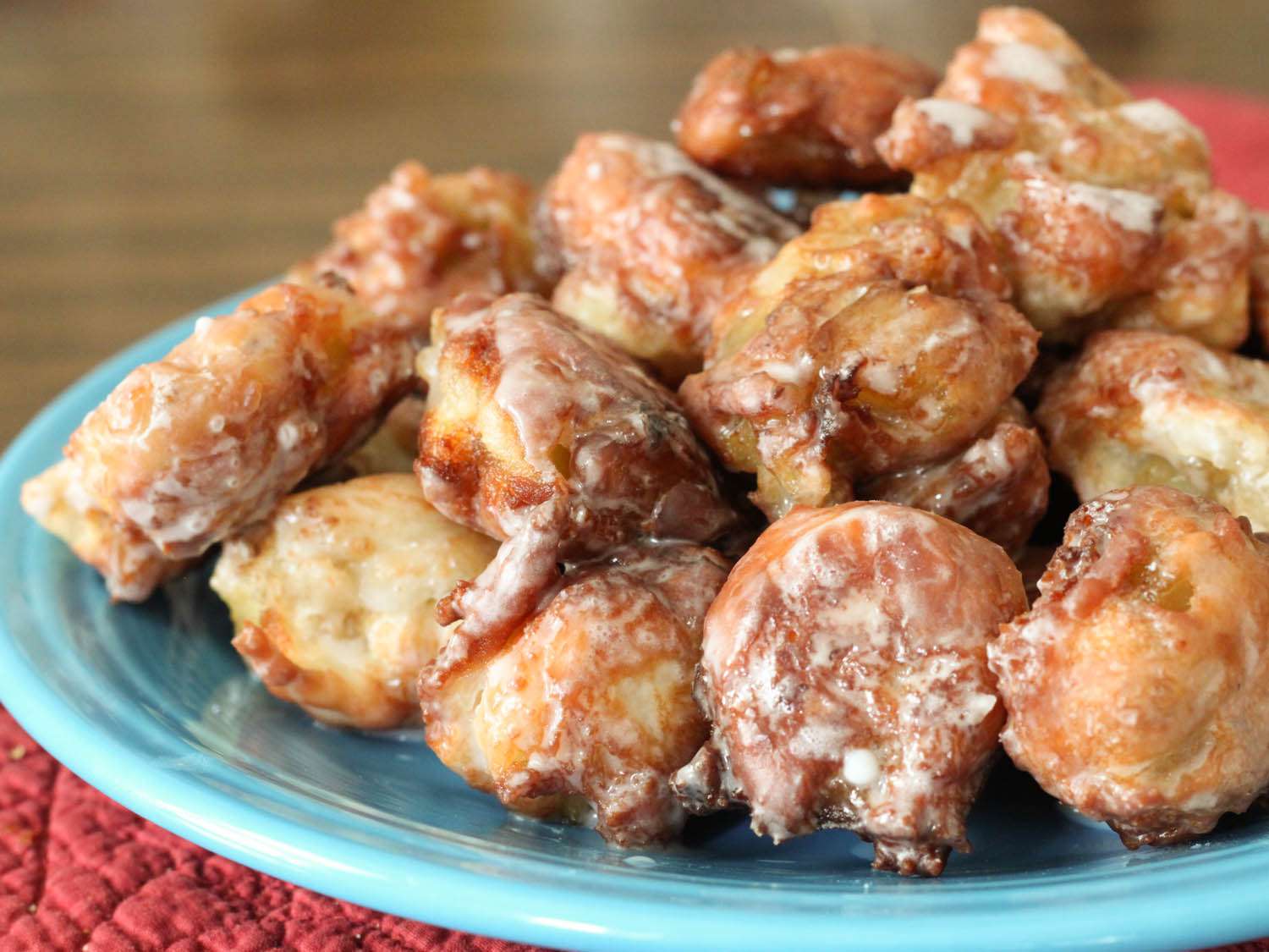 Closeup of gluten-free apple fritters heaped on a turquoise plate.