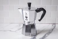 The Bialetti Moka Express moka pot sitting on a marble surface.