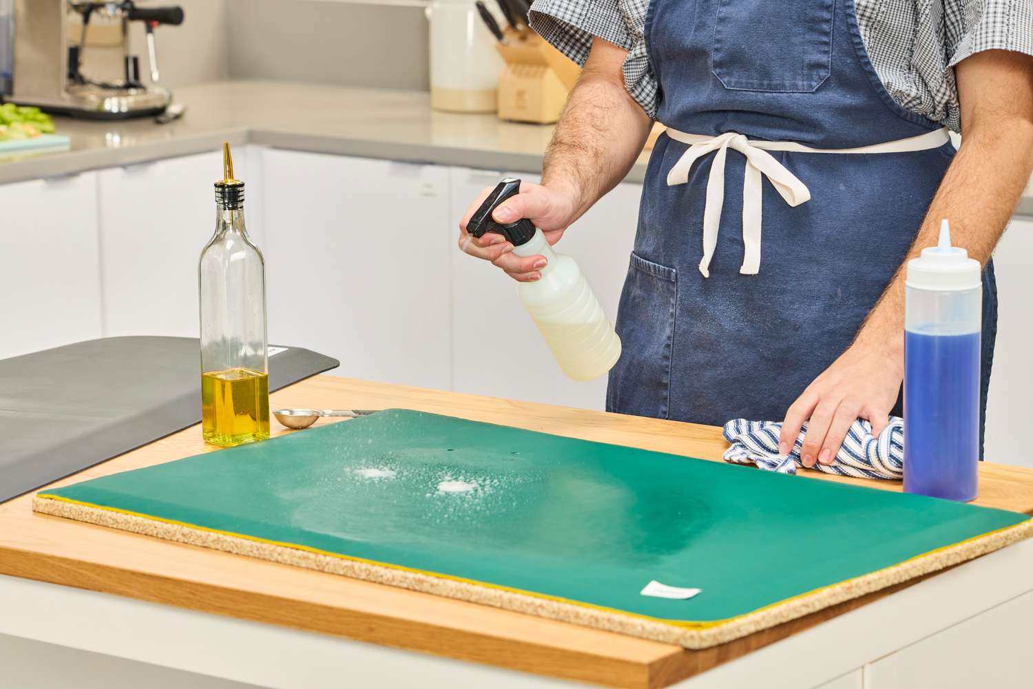 A person sprays cleaner onto the Fulton Standing Mat