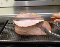 a person slicing ham