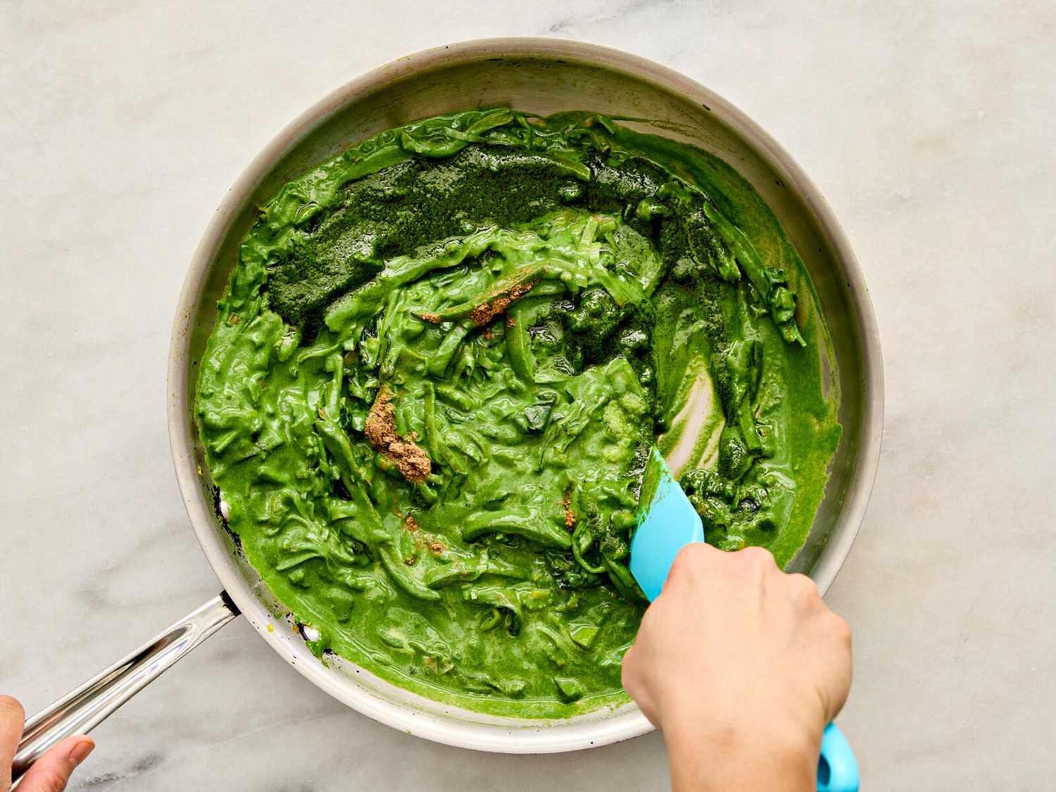 Adding spinach puree to skillet with vegetables 