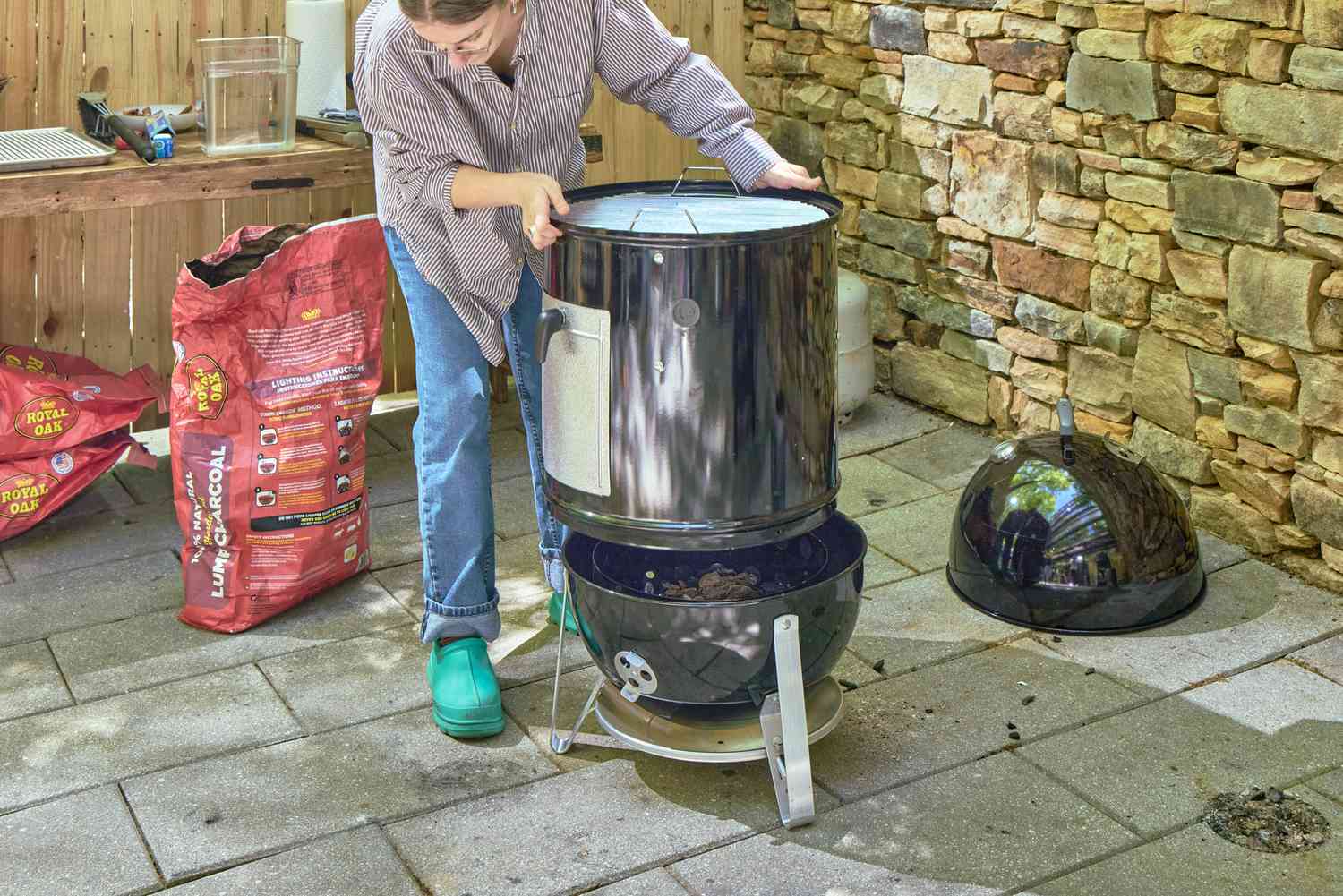A person assembles the Weber 18-Inch Smokey Mountain Cooker
